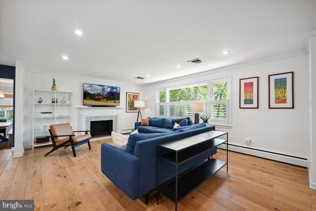 living area with a fireplace with flush hearth, recessed lighting, light wood-style flooring, and visible vents