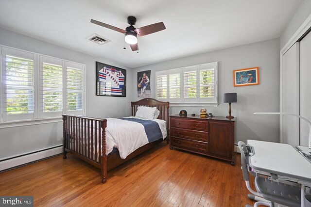 bedroom with ceiling fan, visible vents, light wood-style flooring, and a closet