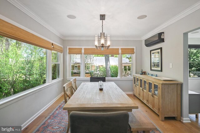 dining area featuring light wood-type flooring, a wall mounted air conditioner, baseboards, and a chandelier