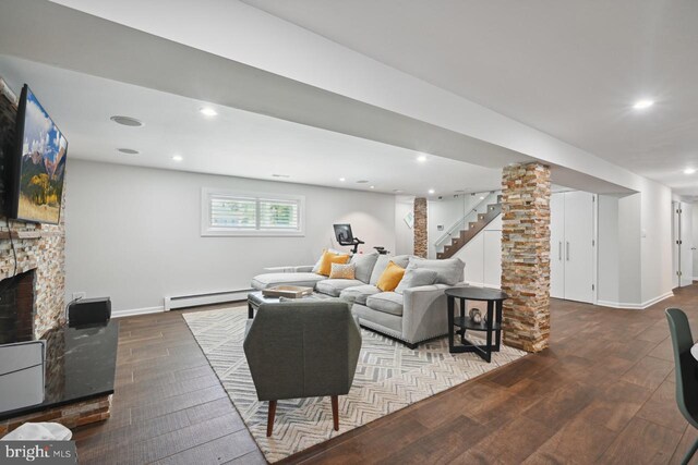 living area featuring a fireplace, stairs, baseboards, a baseboard radiator, and hardwood / wood-style flooring