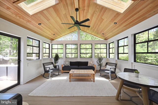 sunroom featuring an outdoor hangout area, ceiling fan, vaulted ceiling with skylight, wooden ceiling, and a wealth of natural light