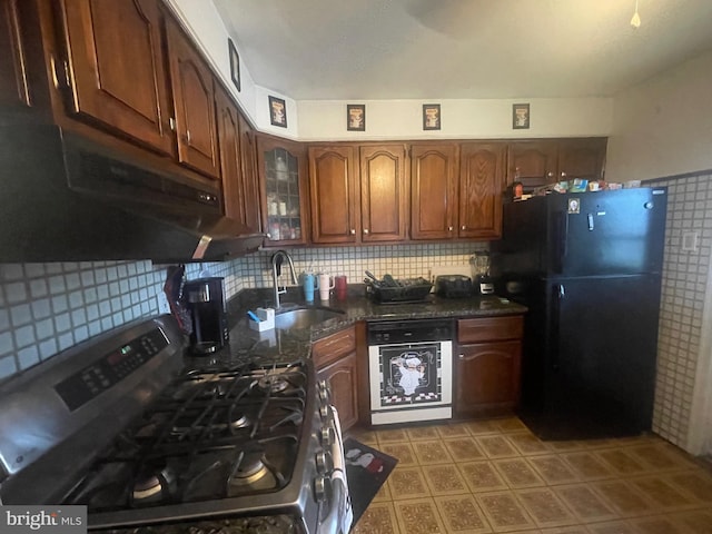 kitchen featuring freestanding refrigerator, stainless steel gas stove, a sink, wall oven, and backsplash