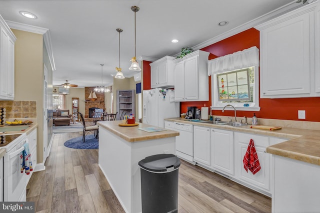 33 Douglas St, Reedville, VA 22539 - kitchen with a sink, a fireplace, a center island, crown molding, and white appliances