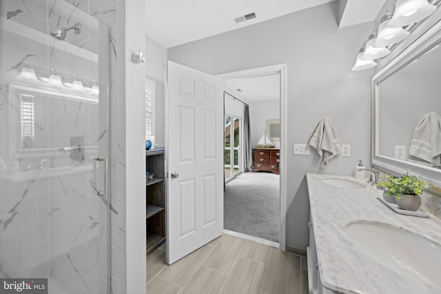 ensuite bathroom featuring visible vents, a marble finish shower, and a sink