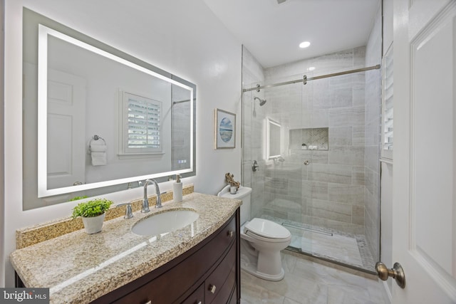 bathroom featuring a stall shower, toilet, and vanity
