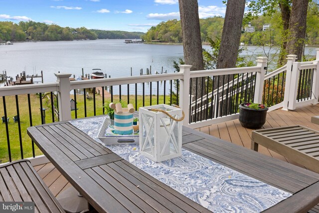 wooden terrace with a dock, a water view, and boat lift