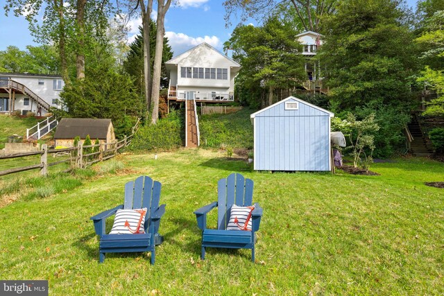 view of yard with stairway, fence, an outdoor structure, and a shed