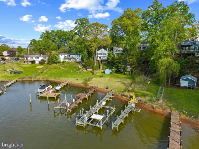 dock area featuring a lawn, a water view, and boat lift