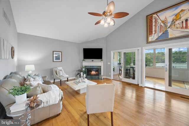 living room featuring visible vents, ceiling fan, high vaulted ceiling, and a high end fireplace