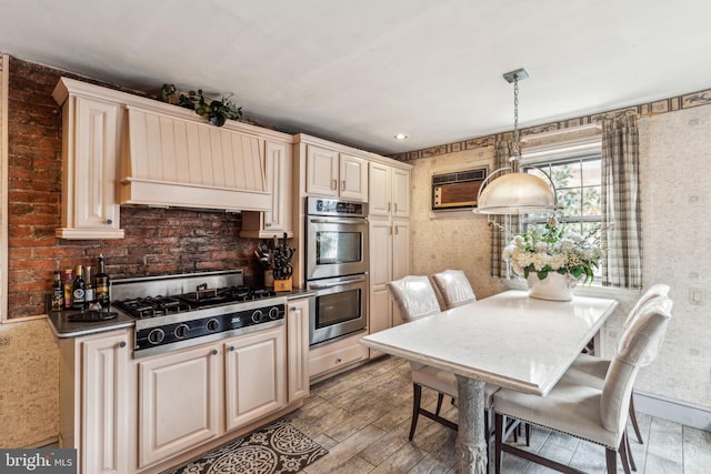 2217 Locust St, Philadelphia, PA 19103 - kitchen with wallpapered walls, gas cooktop, stainless steel double oven, a wall mounted AC, and cream cabinets