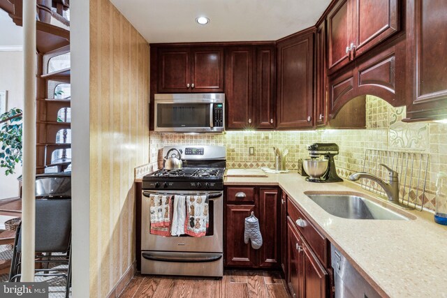 2217 Locust St, Philadelphia, PA 19103 - kitchen with a sink, appliances with stainless steel finishes, reddish brown cabinets, dark wood-style floors, and backsplash