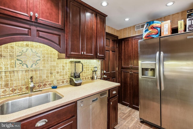 2217 Locust St, Philadelphia, PA 19103 - kitchen with tasteful backsplash, reddish brown cabinets, appliances with stainless steel finishes, a sink, and visible vents