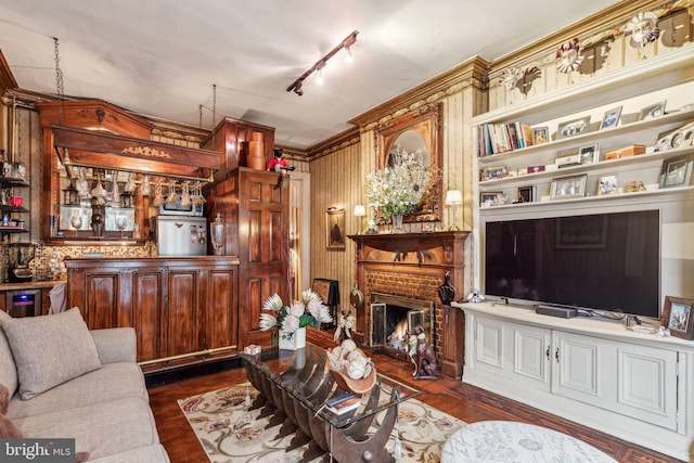 2217 Locust St, Philadelphia, PA 19103 - living area featuring track lighting, crown molding, a brick fireplace, a bar, and dark wood-type flooring