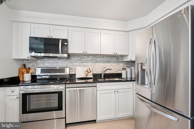 1301 N Courthouse Rd Unit 1812, Arlington, VA 22201 - kitchen featuring appliances with stainless steel finishes, white cabinetry, tasteful backsplash, and dark stone counters