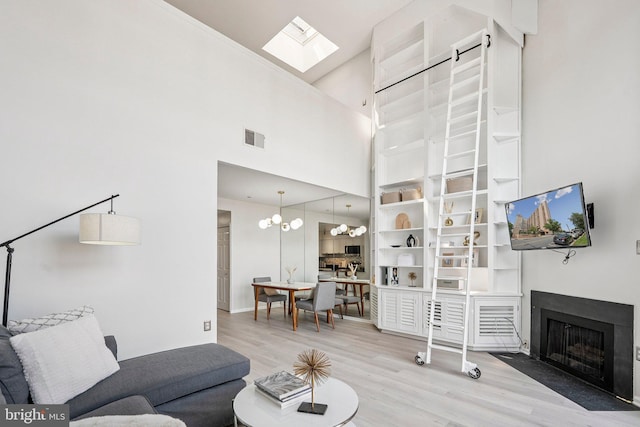 1301 N Courthouse Rd Unit 1812, Arlington, VA 22201 - living area with wood finished floors, a fireplace with flush hearth, a towering ceiling, a skylight, and a chandelier