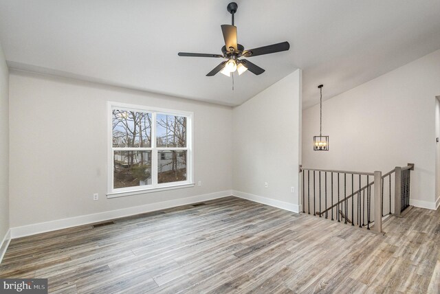 5 Cornwallis Cv, Ruther Glen, VA 22546 - empty room featuring baseboards, wood finished floors, ceiling fan with notable chandelier, and vaulted ceiling