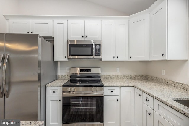 5 Cornwallis Cv, Ruther Glen, VA 22546 - kitchen with white cabinetry, light stone countertops, stainless steel appliances, and lofted ceiling