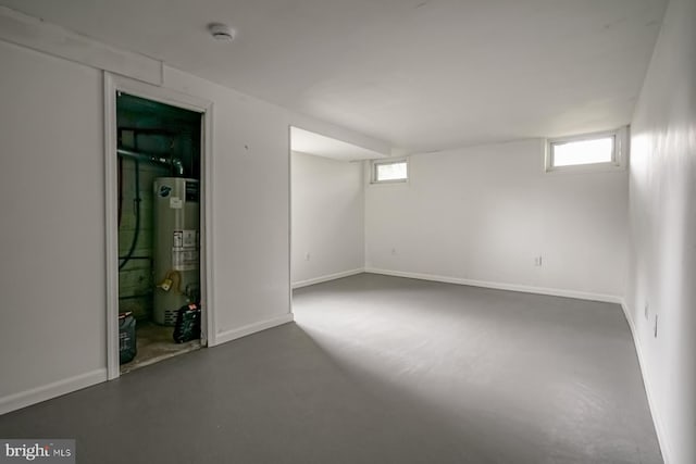 basement with water heater, plenty of natural light, and baseboards