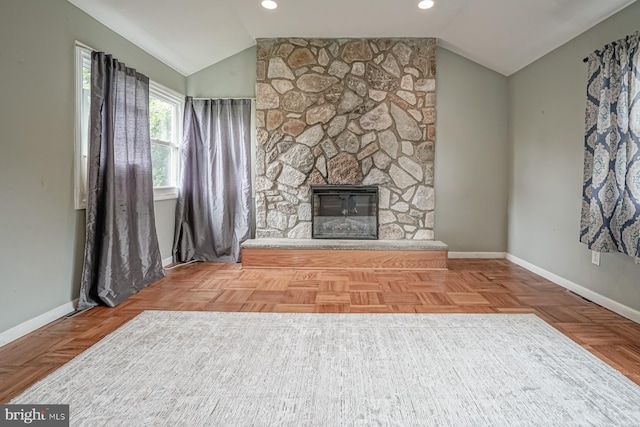 unfurnished living room with lofted ceiling, baseboards, a stone fireplace, and recessed lighting
