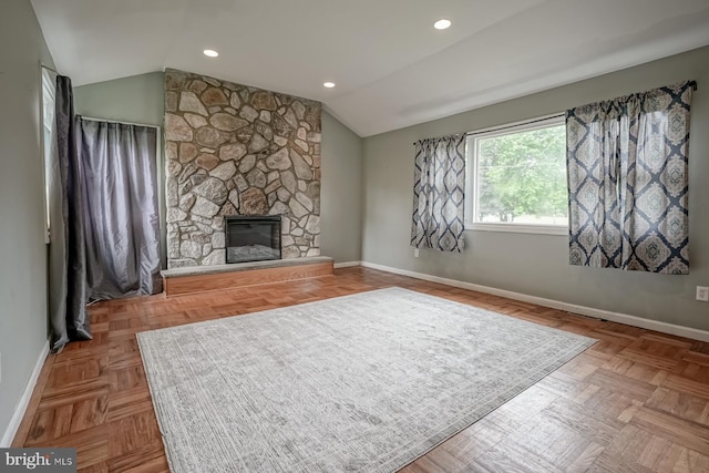unfurnished living room with lofted ceiling, baseboards, a stone fireplace, and recessed lighting