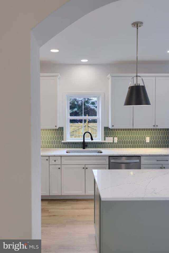 520 Woodcrest Ave, Lititz, PA 17543 - kitchen featuring white cabinetry, tasteful backsplash, stainless steel dishwasher, a sink, and light wood finished floors