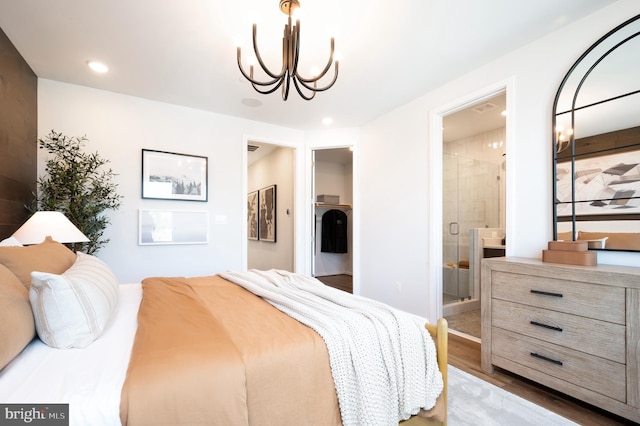 bedroom featuring wood finished floors, connected bathroom, recessed lighting, and a notable chandelier