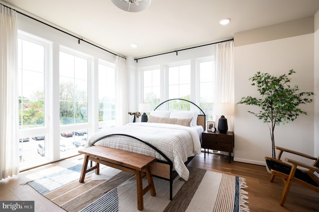 bedroom with recessed lighting, wood finished floors, and baseboards