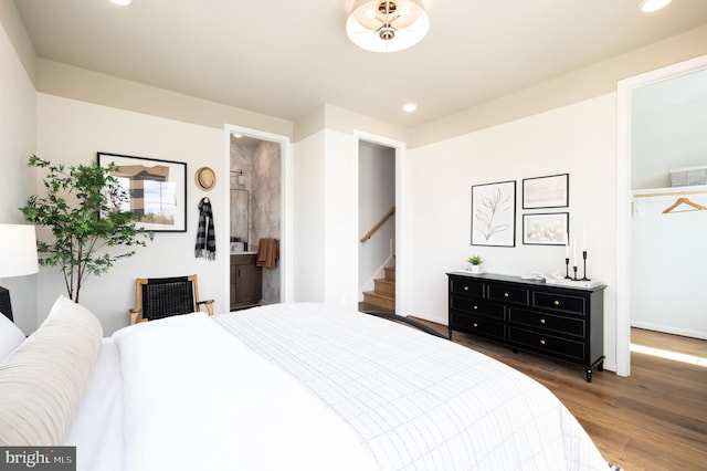 bedroom with baseboards, recessed lighting, wood finished floors, and a spacious closet