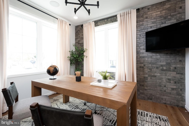office space with recessed lighting, wood finished floors, and brick wall