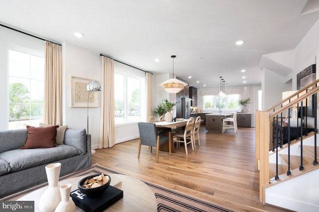 living room with stairway, light wood-style floors, recessed lighting, and baseboards