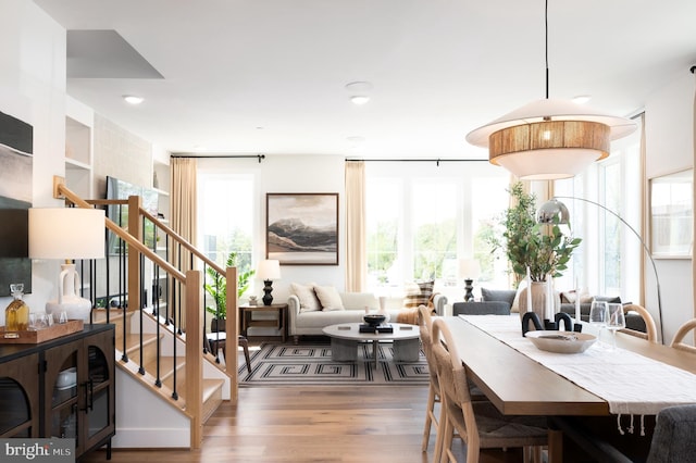dining space with stairway and wood finished floors