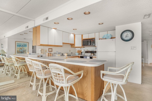 423 14th St Unit 205K, Ocean City, MD 21842 - kitchen featuring a peninsula, freestanding refrigerator, black microwave, light countertops, and electric range oven