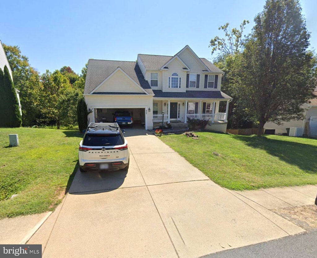 view of front of home with a porch, driveway, a front yard, and a garage