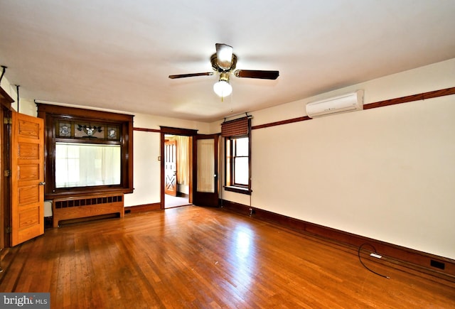 133 Main St, East Greenville, PA 18041 - unfurnished living room featuring radiator, a wall mounted air conditioner, wood finished floors, a ceiling fan, and baseboards