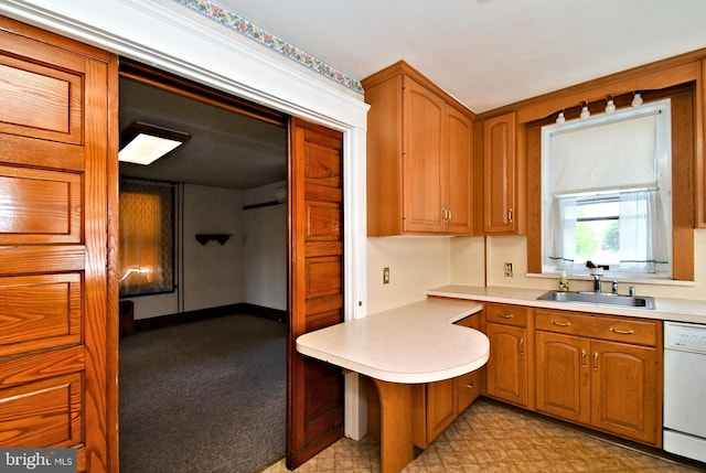 133 Main St, East Greenville, PA 18041 - kitchen featuring white dishwasher, a sink, a peninsula, light countertops, and brown cabinetry