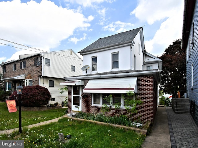 133 Main St, East Greenville, PA 18041 - view of front of home with brick siding, stucco siding, a front lawn, and a shingled roof