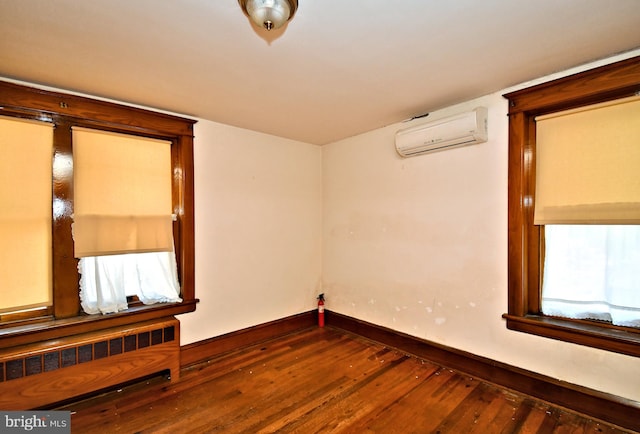 133 Main St, East Greenville, PA 18041 - empty room featuring a wall mounted air conditioner, radiator, wood finished floors, and baseboards