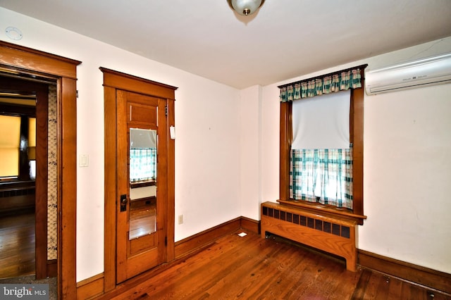 133 Main St, East Greenville, PA 18041 - empty room with dark wood finished floors, baseboards, a wall mounted air conditioner, and radiator