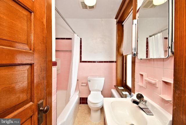 133 Main St, East Greenville, PA 18041 - bathroom with tile walls, a sink, toilet, shower / bath combo with shower curtain, and wainscoting