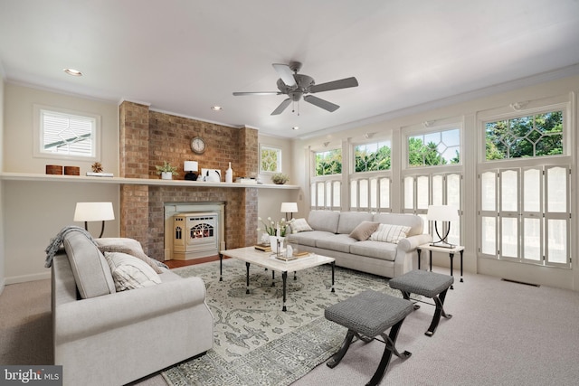 living area with crown molding, a ceiling fan, and a wealth of natural light