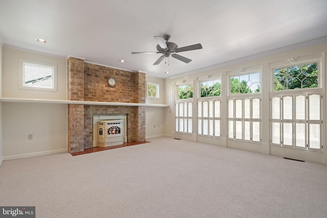 unfurnished living room with ornamental molding, carpet, a ceiling fan, and a fireplace