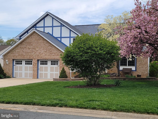 tudor-style house with brick siding, an attached garage, driveway, and a front lawn