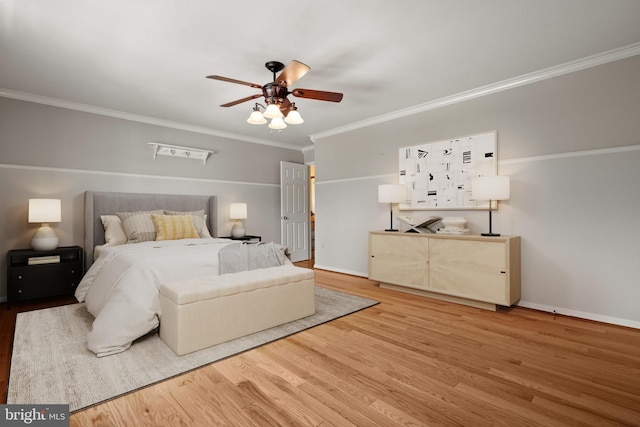 bedroom with crown molding, a ceiling fan, baseboards, and wood finished floors