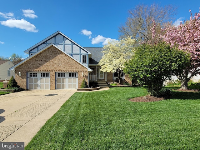view of front of property with a garage, driveway, a front lawn, and brick siding