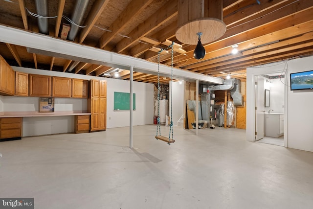 unfinished below grade area featuring built in study area and gas water heater