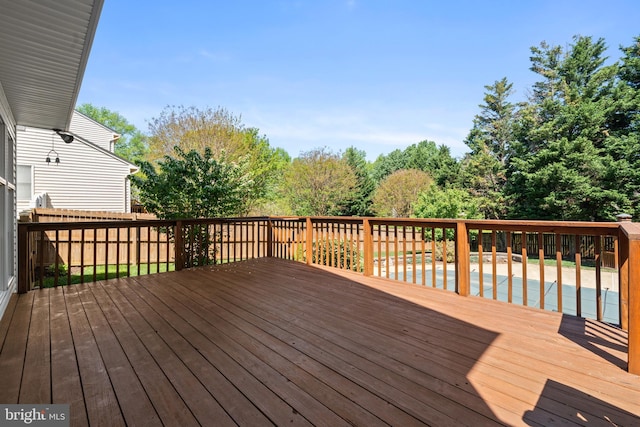 wooden deck with a fenced in pool and fence