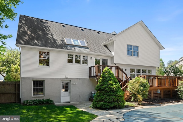 back of house with fence, a wooden deck, stairs, and a fenced in pool