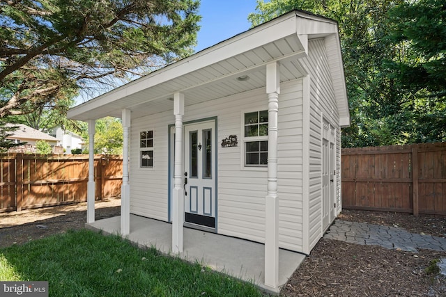view of outdoor structure with a fenced backyard and an outbuilding