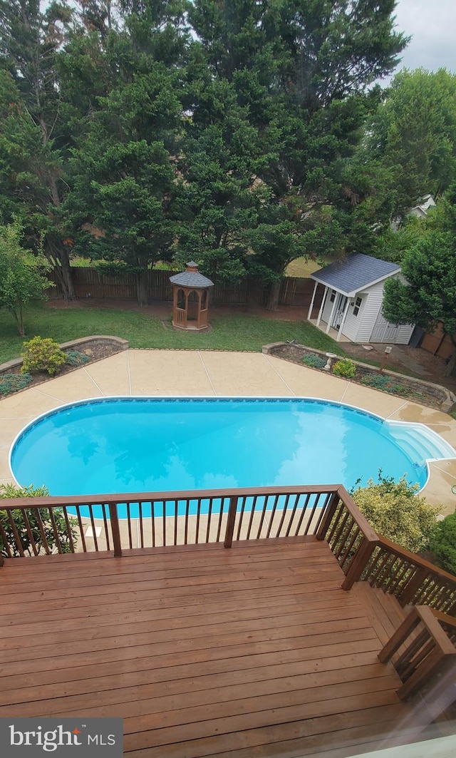 view of swimming pool with a deck, an outbuilding, a gazebo, a fenced in pool, and a fenced backyard