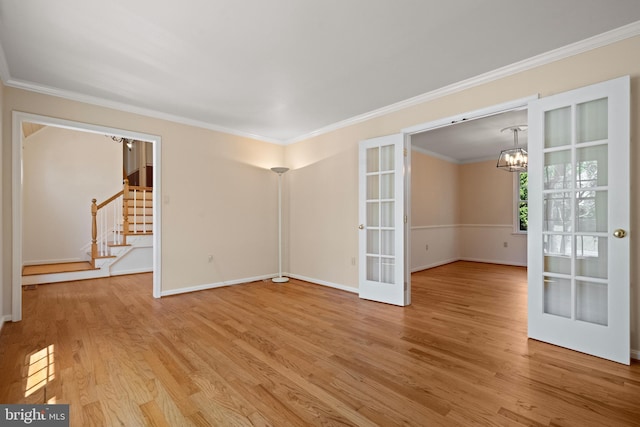 unfurnished living room featuring a notable chandelier, french doors, stairway, and wood finished floors